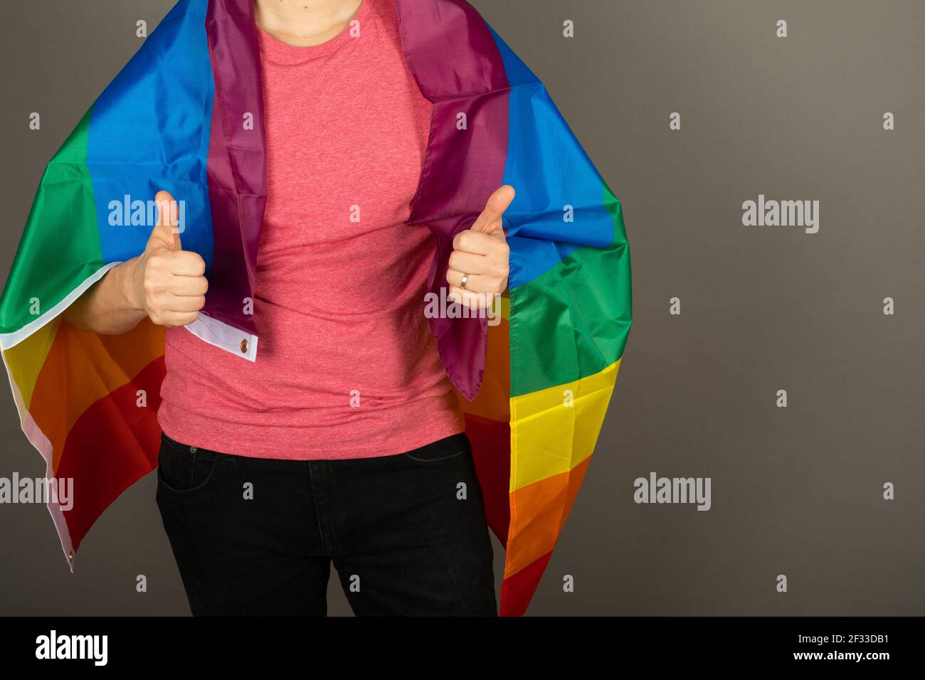 Homme gay portant un t-shirt rose et un drapeau arc-en-ciel Banque D'Images