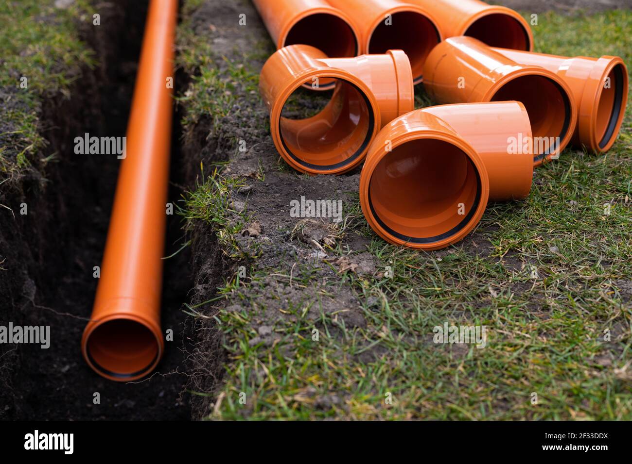 Pose des tuyaux d'évacuation en PVC orange dans le sol Photo Stock - Alamy