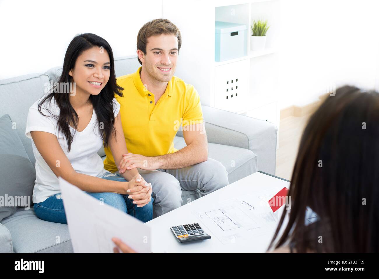 Jeune couple interracial rencontre avec un agent immobilier (ou conseiller financier) à la maison Banque D'Images