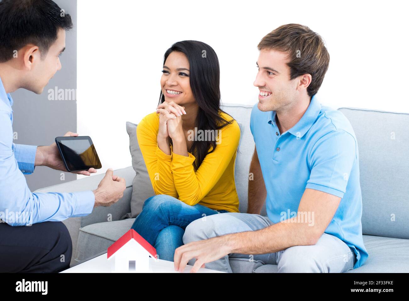 Jeune couple interracial rencontre avec un agent immobilier (ou conseiller financier) à la maison Banque D'Images