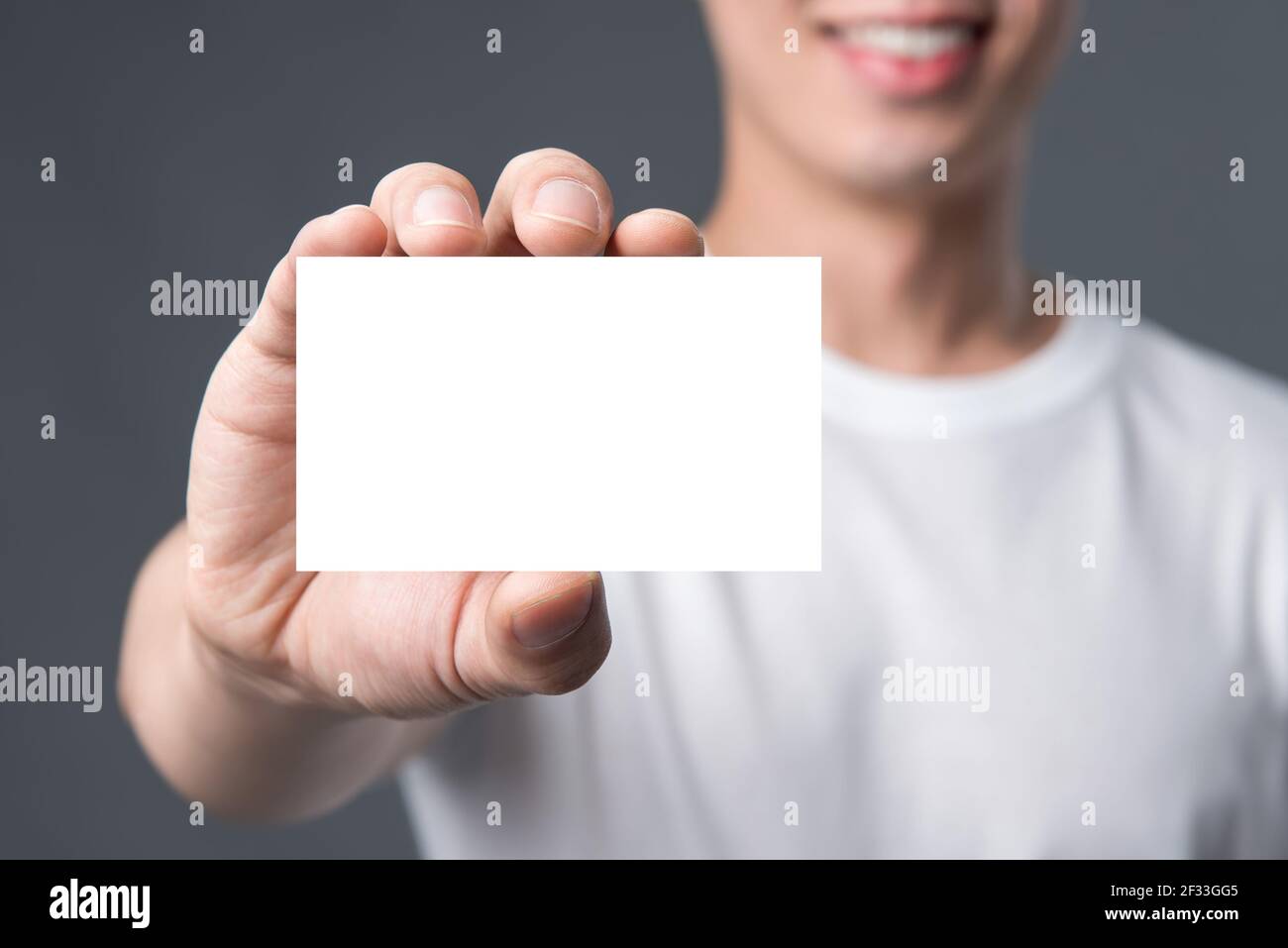 Jeune homme montrant une carte de visite blanche vierge Banque D'Images