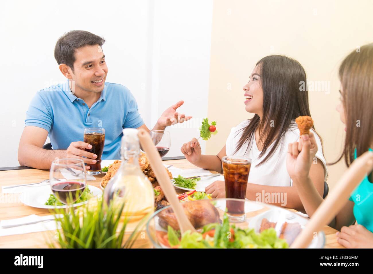 Les gens apprécient de manger et d'avoir la conversation à la table de salle à manger Banque D'Images