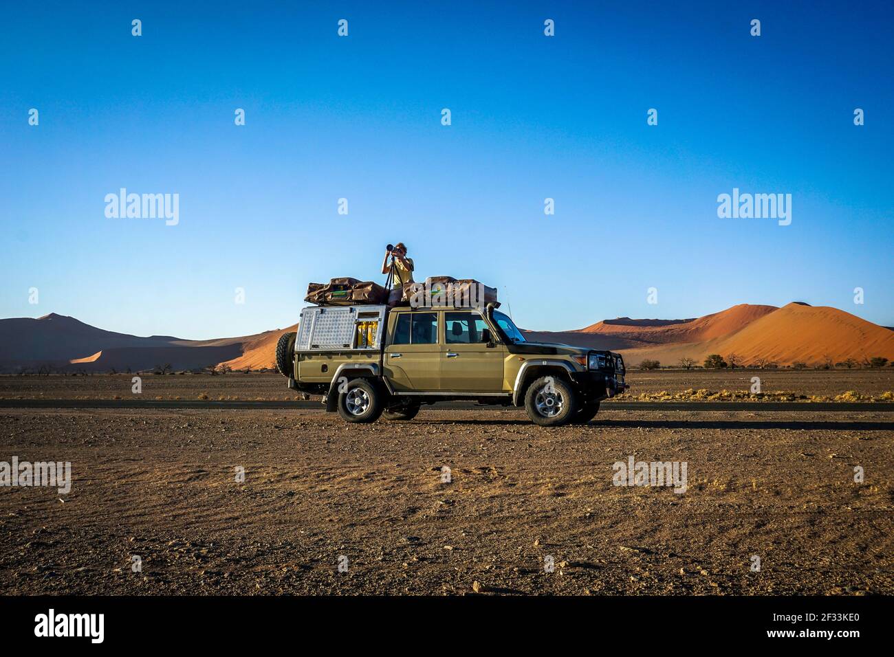Un photographe au sommet d'un 4x4 dans le désert de sossusvlei, namibie. Banque D'Images