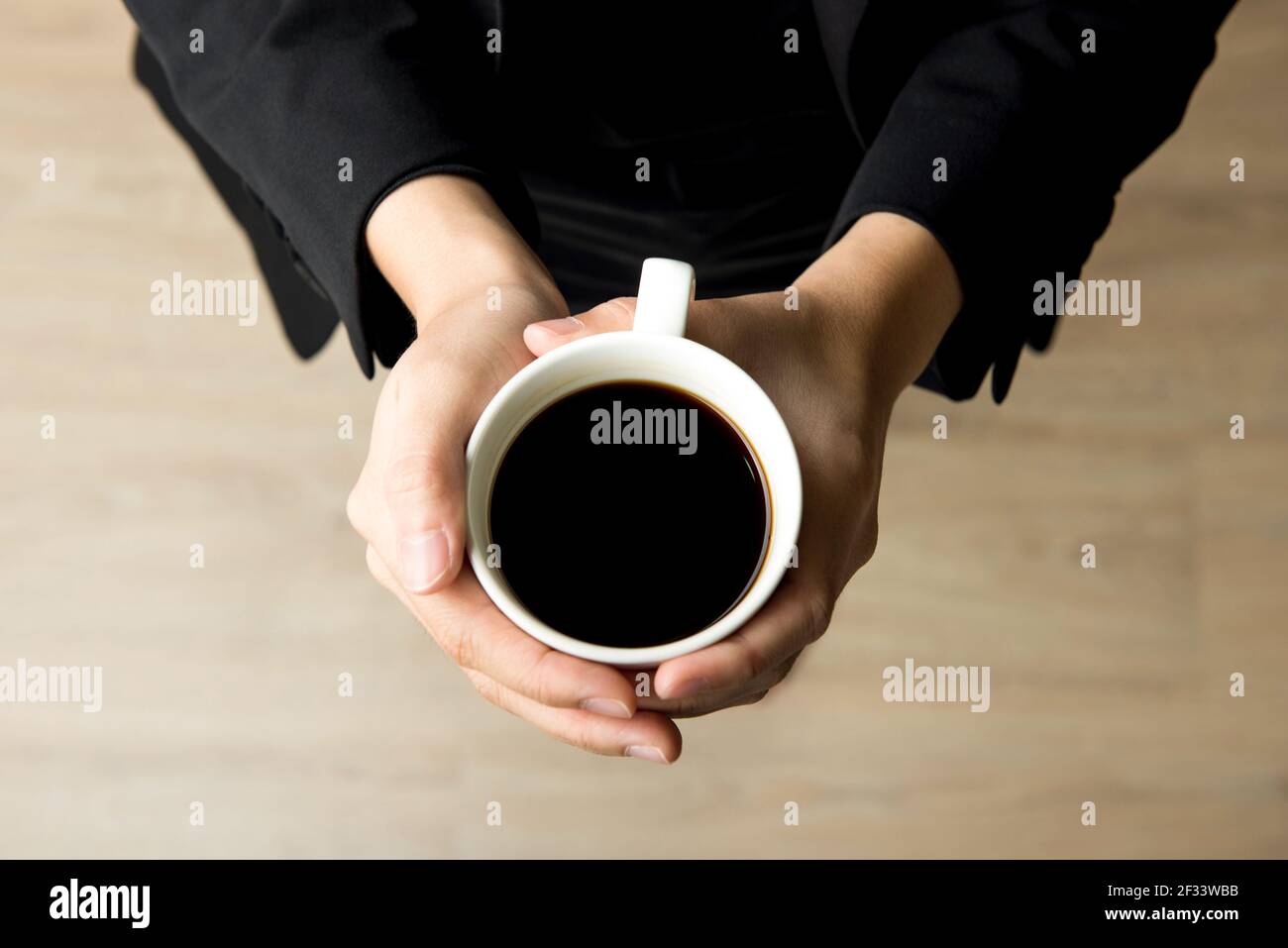 Femme mains tenant une tasse de café avec du café noir - dessus vue Banque D'Images