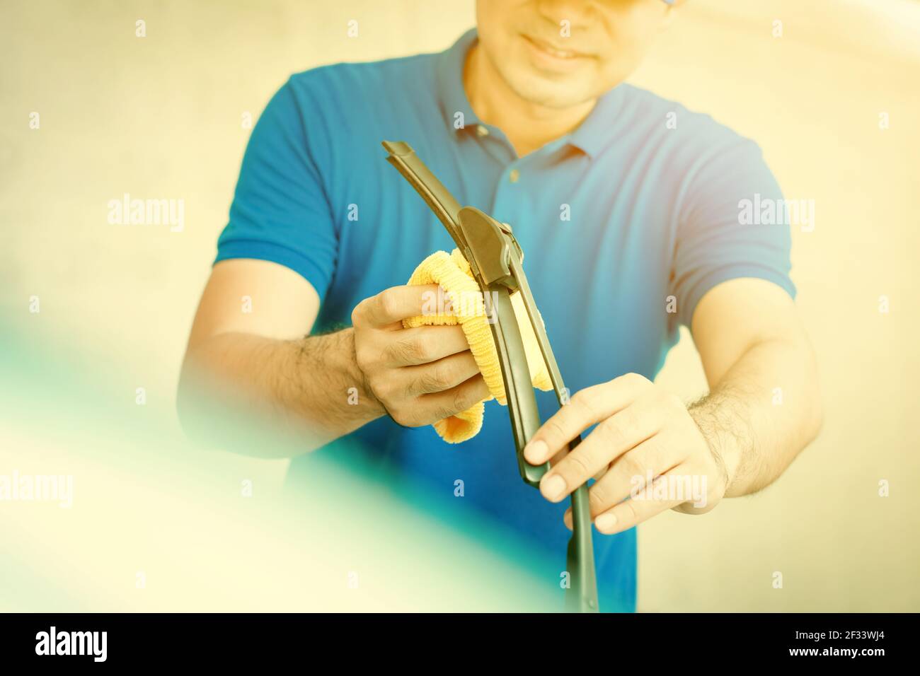 Un homme nettoyant essuie-glace de voiture (pare-brise) - habillage de voiture et le concept de la cantonnière Banque D'Images Un homme nettoyant essuie-glace de voiture (pare-brise) - habillage de voiture et le concept de la cantonnière Banque D'Images