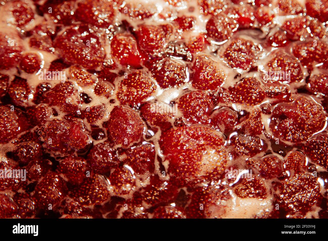 Faire une confiture de fraises. Faire bouillir les fraises dans la casserole. Banque D'Images