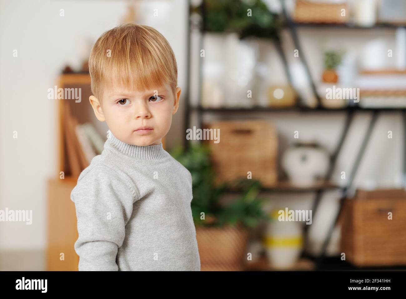 Portrait d'un petit garçon mignon avec des cheveux blonds debout la chambre Banque D'Images