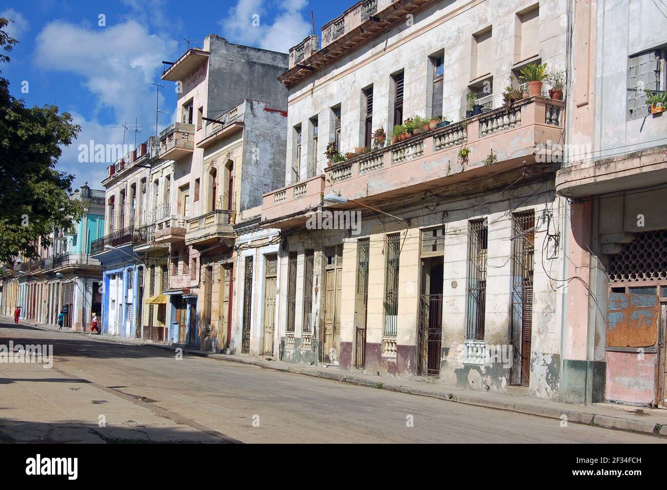 La Havane, Cuba - le 14 novembre 2007 : piétons marchant le long d'une rue résidentielle dans le centre de la Havane avec des maisons élégantes et en panne. Banque D'Images