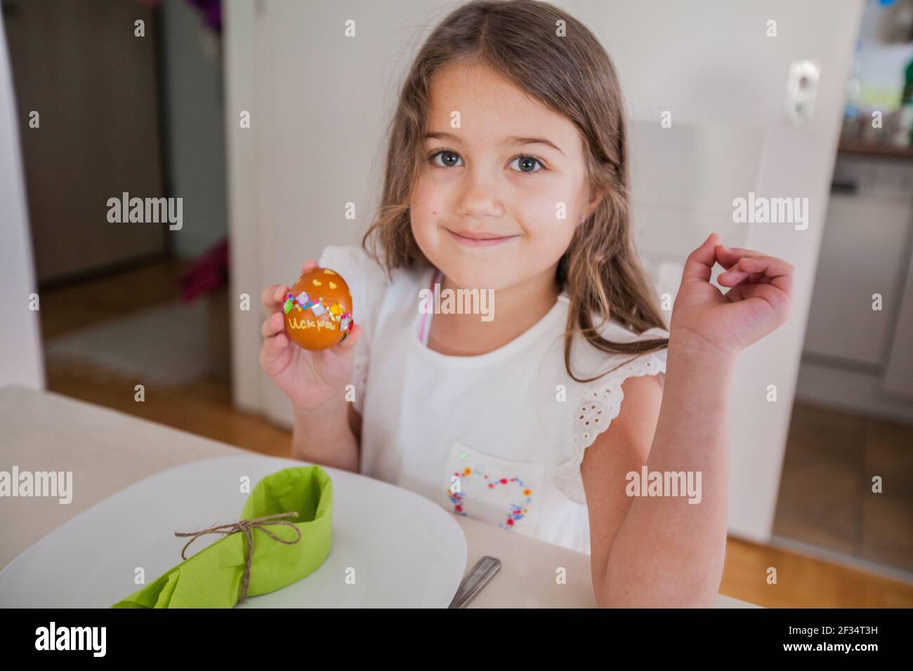 Portrait d'une adorable petite fille avec des œufs de Pâques colorés à la maison, jour des fêtes Banque D'Images