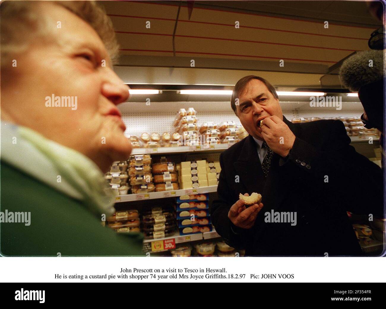 John Prescott, député, chef adjoint du Parti travailliste, lors d'une visite dans un magasin de Tesco à Heswell. Il mange une tarte à la crème pendant qu'il est accompagné de Mme Joyce Griffiths Banque D'Images