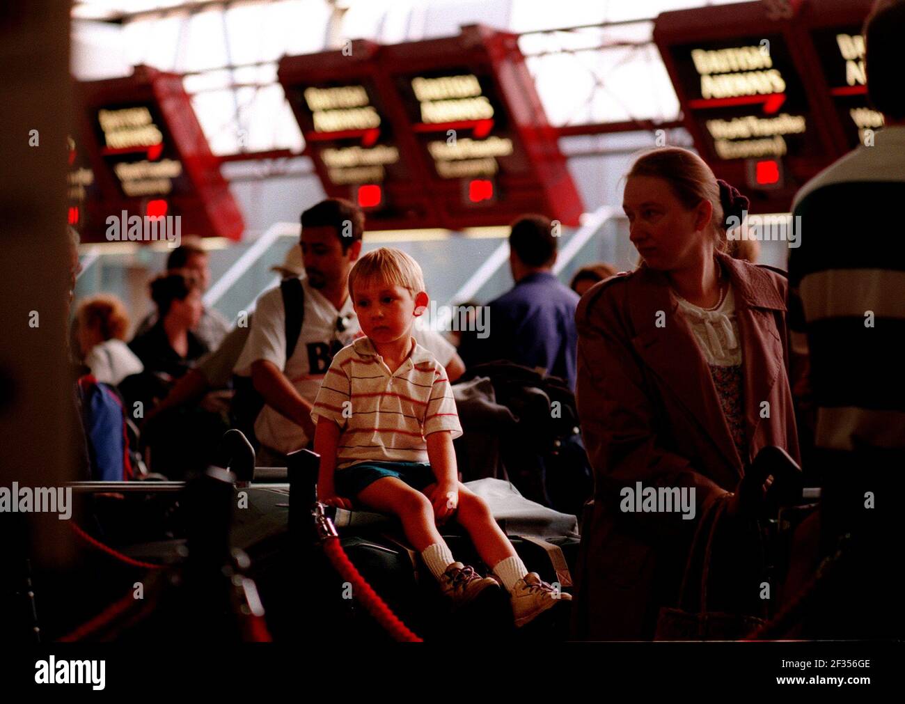 Josh, quatre ans, attend avec ses parents à l'aéroport de heathrow un transfert à Air Canada de British Airways pour un vol à destination de Toronto. Banque D'Images