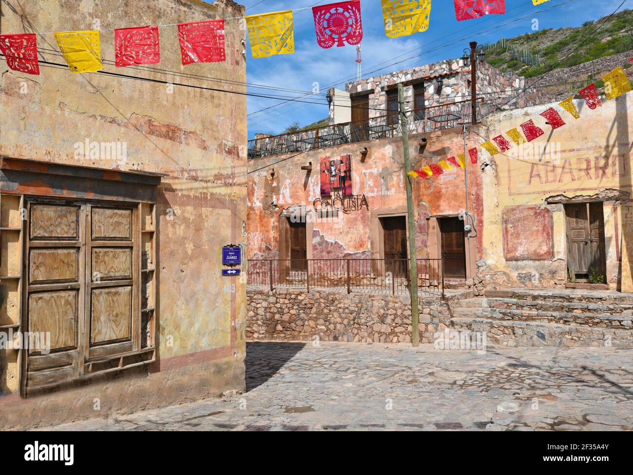 Fête religieuse folk mexicaine rouge et jaune Art papel picado contre les bâtiments historiques coloniaux à Cerro de San Pedro, San Luis Potosí Mexique. Banque D'Images