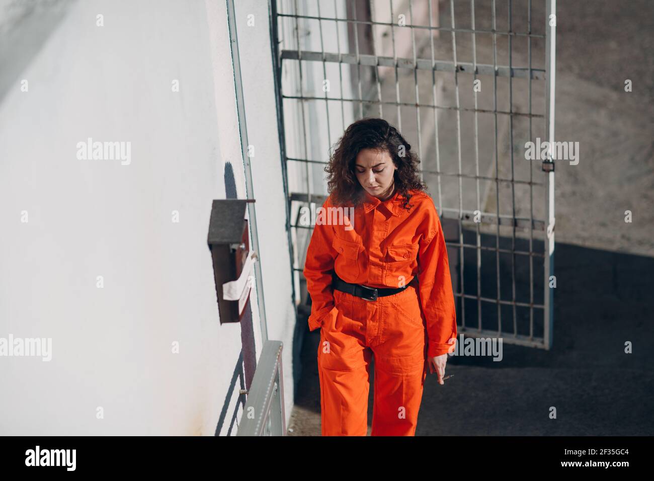 Jeune femme prisonnière en costume orange en prison fumeur. Femme en  portrait de combinaison colorée Photo Stock - Alamy