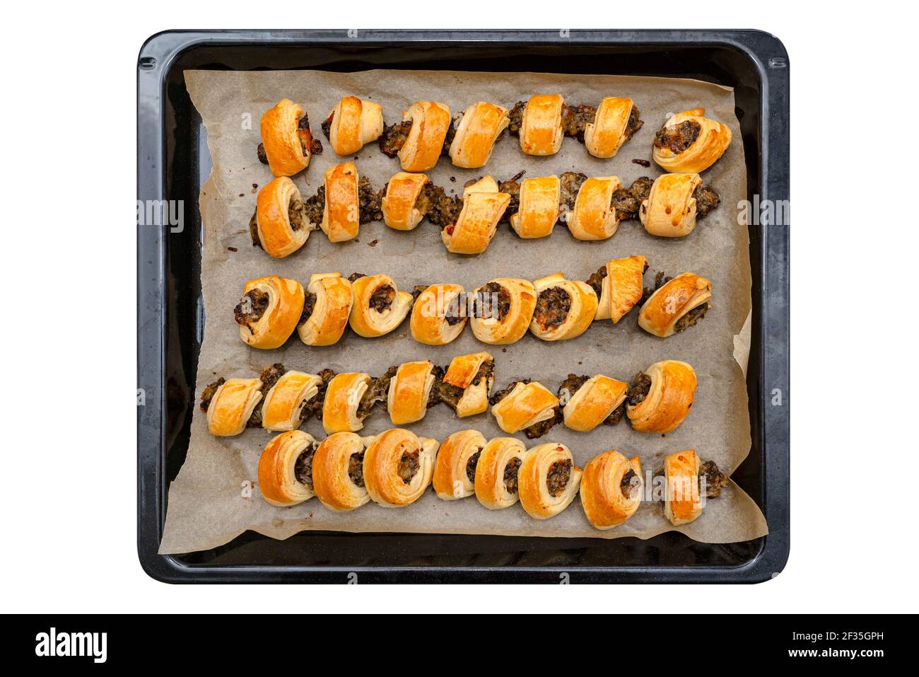 Pate cuite dans une pâte posée sur un plateau de papier de cuisson, isolée sur un fond blanc avec un chemin de découpe, vue du dessus. Banque D'Images