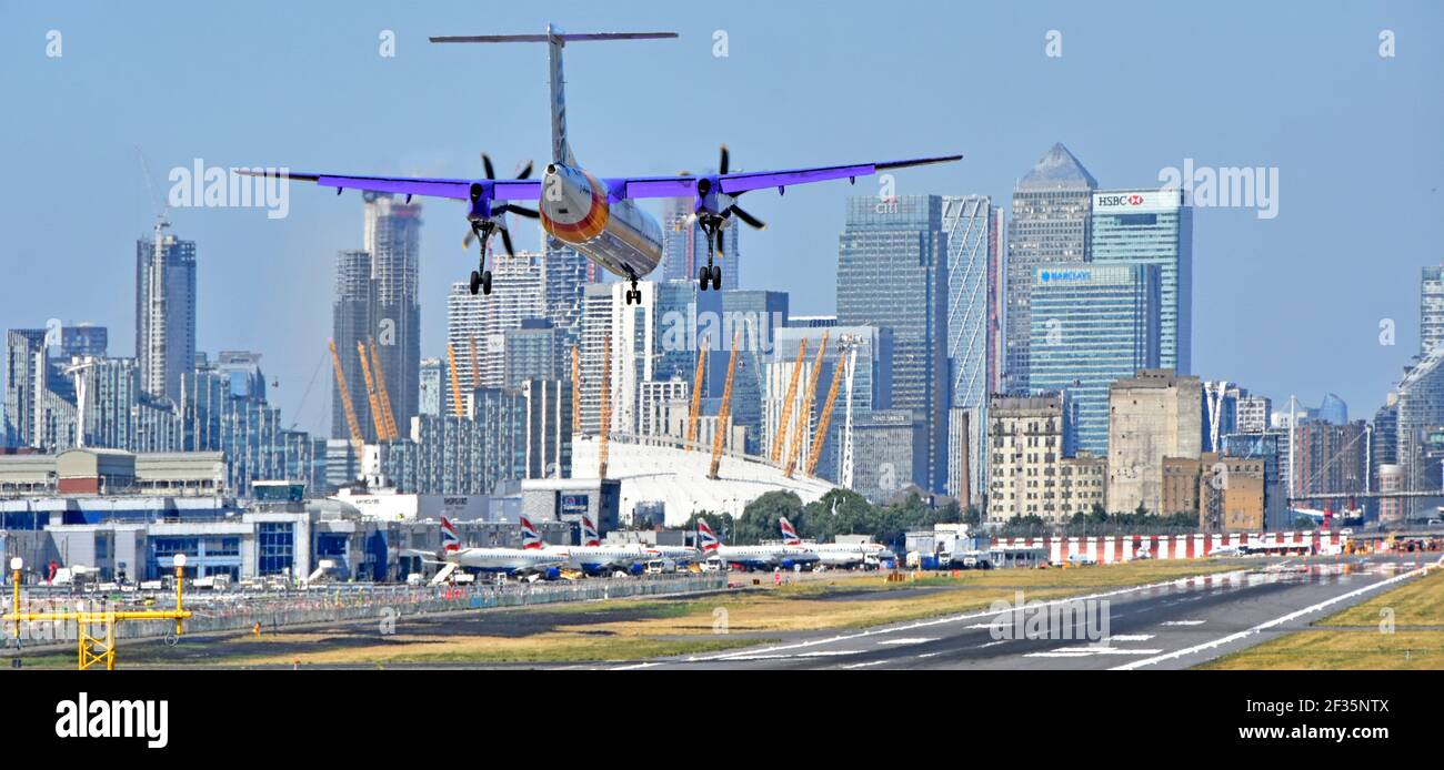 Avion turbopropulseur Flybe débarquant sur la piste d'atterrissage de l'aéroport de London City Newham O2 arena & Canary Wharf Londres Docklands Skyline au-delà de Tower Hamlets Angleterre Royaume-Uni Banque D'Images