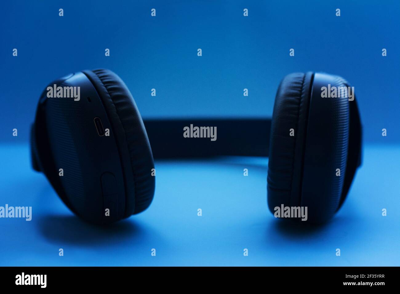 Casque sans fil sur fond bleu. Vue en gros plan. Concept de musique. Faible profondeur de champ Banque D'Images