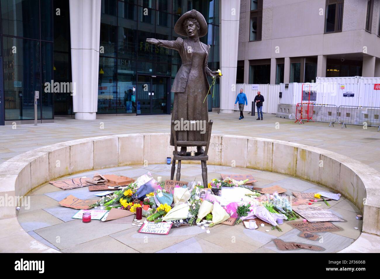 Des placardes qui font pression pour la sécurité des femmes et des fleurs à la statue d'Emmeline Pankhurst sur la place Saint-Pierre, Manchester, Angleterre, Royaume-Uni, sont partis après la vigile à la mémoire de Sarah Everard le 13 mars 2021. Un policier de la région métropolitaine de Londres a été inculpé d'enlèvement et de meurtre de Sarah Everard le 12 mars. Il a comparu devant le tribunal des magistrats de Westminster le 13 mars et a été remis en garde à vue pour comparaître devant le tribunal Old Bailey le 16 mars. Emmeline Pankhurst était le chef du mouvement des suffragettes au Royaume-Uni. La statue de bronze a été sculptée par Hazel Reeves. Banque D'Images