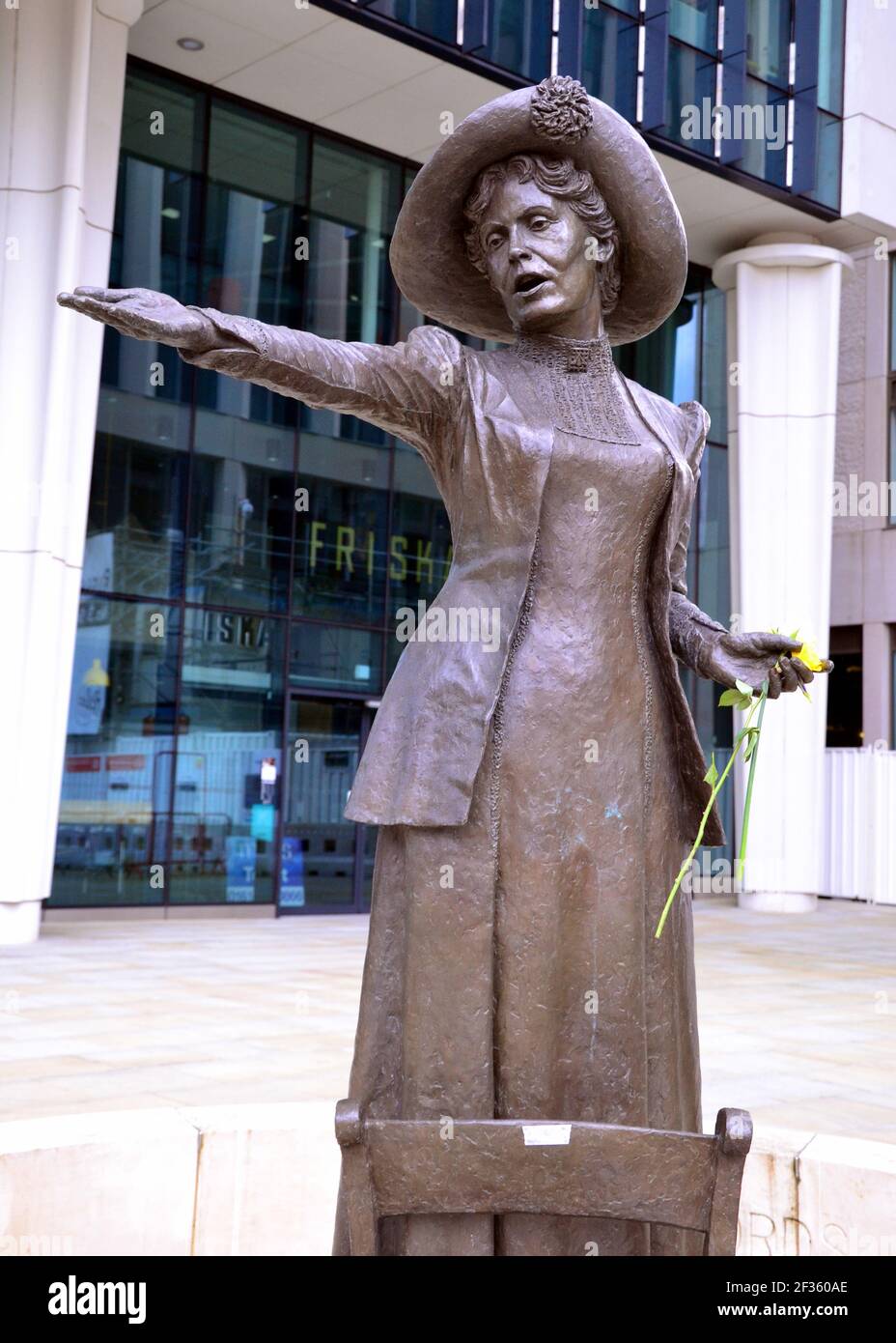 La statue d'Emmeline Pankhurst sur la place Saint-Pierre, Manchester, Angleterre, Royaume-Uni, tient une fleur laissée après la vigile à la mémoire de Sarah Everard le 13 mars 2021. Un policier de la région métropolitaine de Londres a été inculpé d'enlèvement et de meurtre de Sarah Everard le 12 mars. Il a comparu devant le tribunal des magistrats de Westminster le 13 mars et a été remis en garde à vue pour comparaître devant le tribunal Old Bailey le 16 mars. Emmeline Pankhurst était le chef du mouvement des suffragettes au Royaume-Uni. La statue de bronze a été sculptée par Hazel Reeves. Banque D'Images