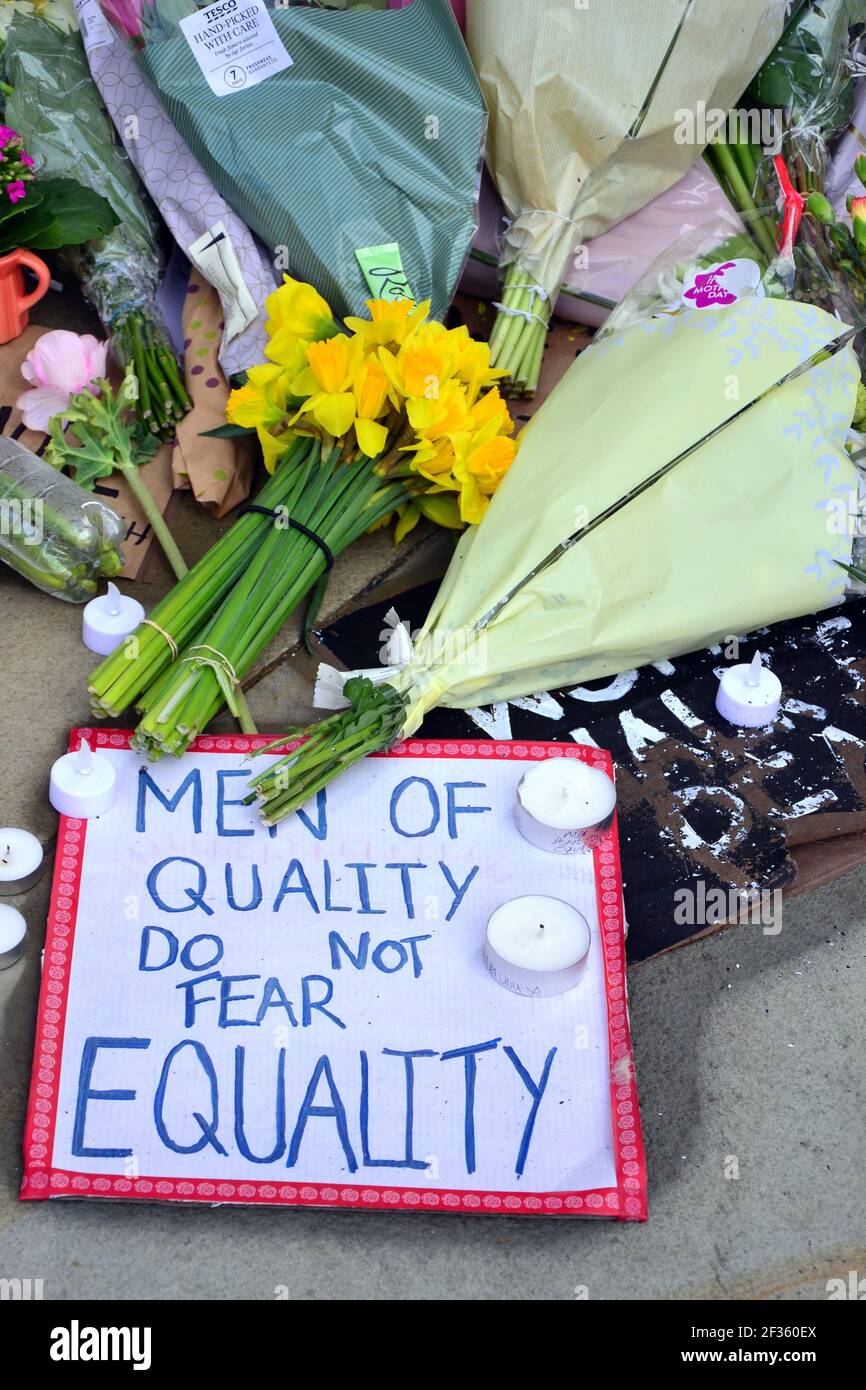 Des placardes qui font pression pour la sécurité des femmes et des fleurs à la statue d'Emmeline Pankhurst sur la place Saint-Pierre, Manchester, Angleterre, Royaume-Uni, sont partis après la vigile à la mémoire de Sarah Everard le 13 mars 2021. Un policier de la région métropolitaine de Londres a été inculpé d'enlèvement et de meurtre de Sarah Everard le 12 mars. Il a comparu devant le tribunal des magistrats de Westminster le 13 mars et a été remis en garde à vue pour comparaître devant le tribunal Old Bailey le 16 mars. Emmeline Pankhurst était le chef du mouvement des suffragettes au Royaume-Uni. La statue de bronze a été sculptée par Hazel Reeves. Banque D'Images