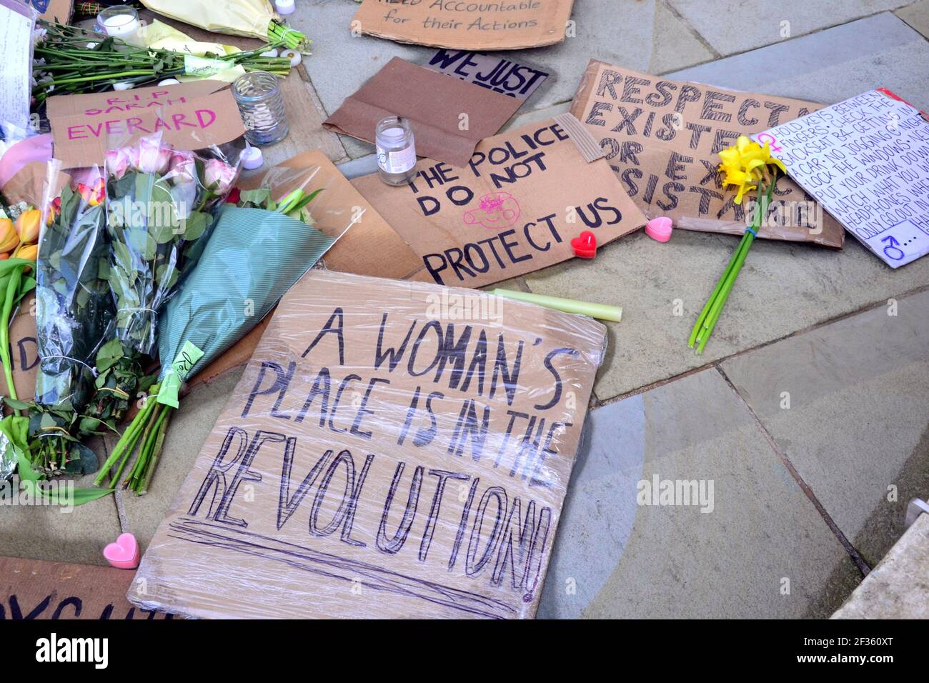 Des placardes qui font pression pour la sécurité des femmes et des fleurs à la statue d'Emmeline Pankhurst sur la place Saint-Pierre, Manchester, Angleterre, Royaume-Uni, sont partis après la vigile à la mémoire de Sarah Everard le 13 mars 2021. Un policier de la région métropolitaine de Londres a été inculpé d'enlèvement et de meurtre de Sarah Everard le 12 mars. Il a comparu devant le tribunal des magistrats de Westminster le 13 mars et a été remis en garde à vue pour comparaître devant le tribunal Old Bailey le 16 mars. Emmeline Pankhurst était le chef du mouvement des suffragettes au Royaume-Uni. La statue de bronze a été sculptée par Hazel Reeves. Banque D'Images