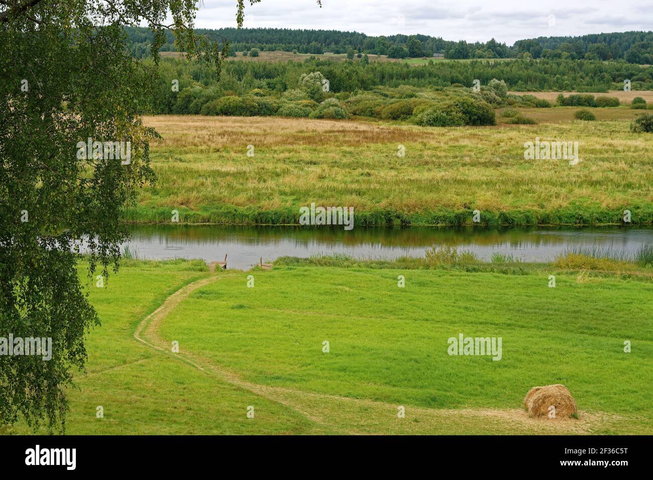 Paysage d'automne avec une rivière, un pré mown et une botte de foin dans la région de Pskov. Banque D'Images
