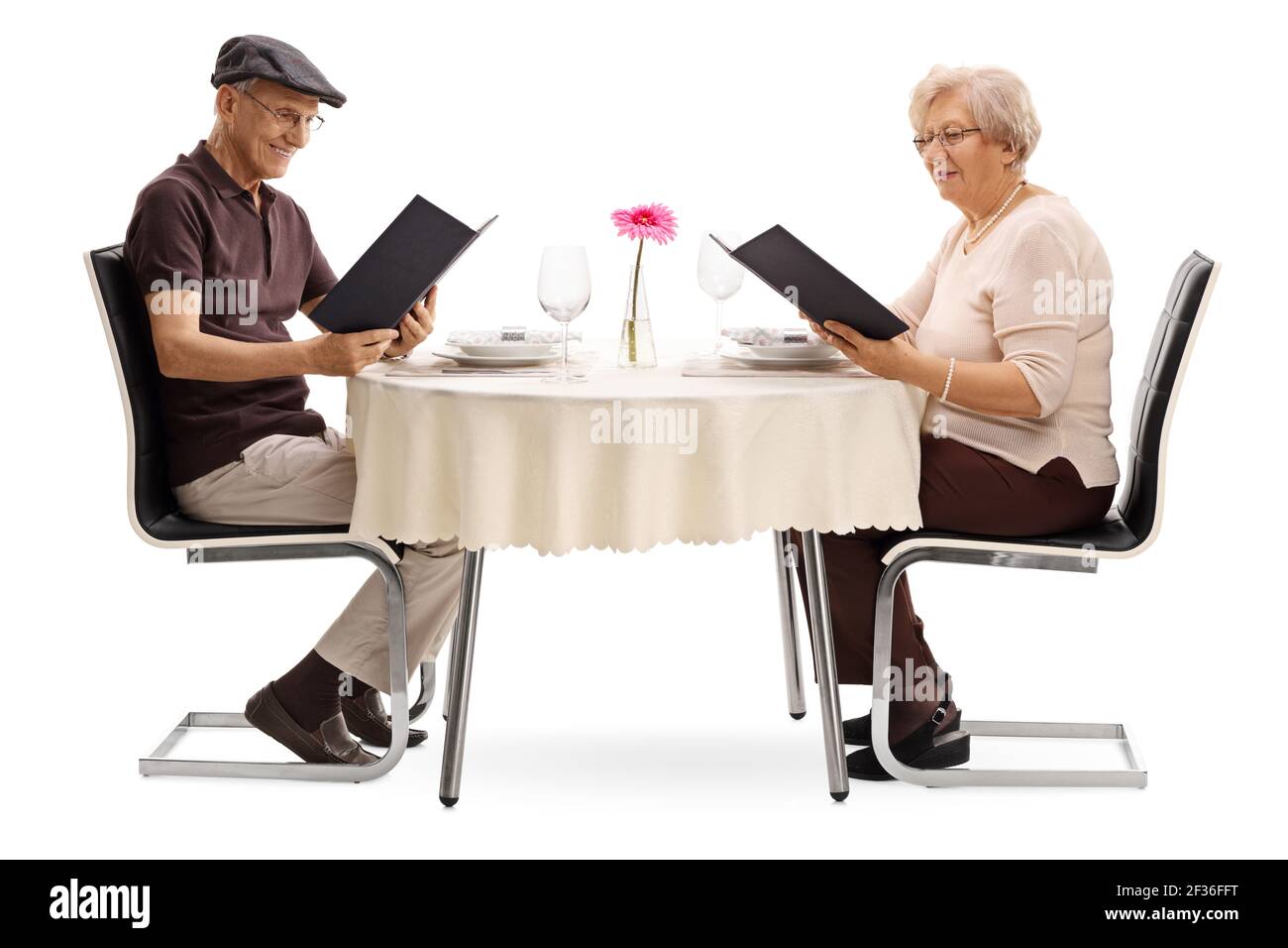 Un couple âgé dans un restaurant lisant les menus isolés arrière-plan blanc Banque D'Images