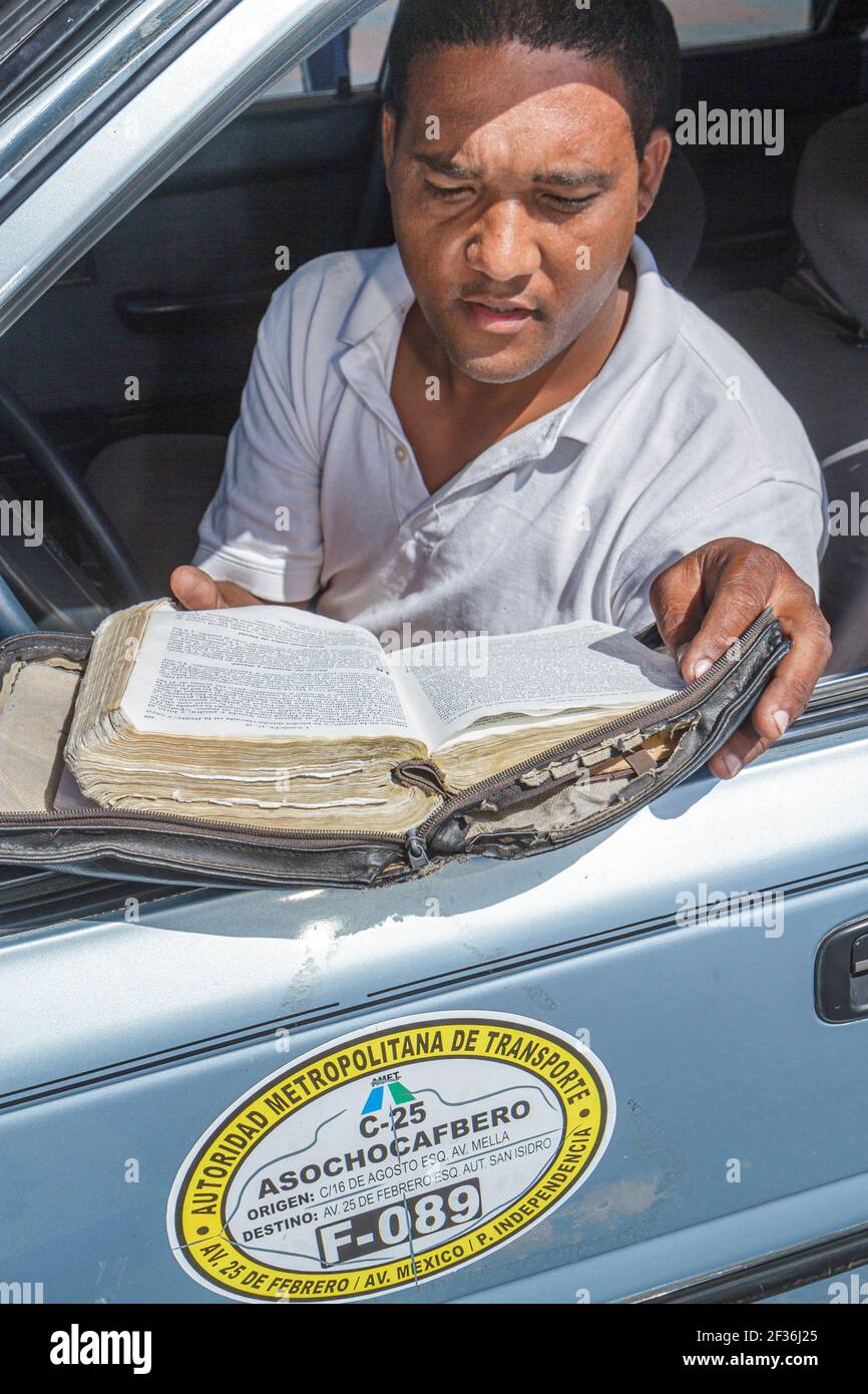 Saint-Domingue République dominicaine, homme hispanique chauffeur de taxi mâle, lecture de la bible, Banque D'Images