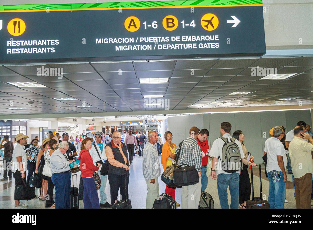 République dominicaine de Saint-Domingue, aéroport international de Las Américas SDQ, ligne de départ de migration file d'attente voyageurs, hommes hispaniques femmes, Banque D'Images