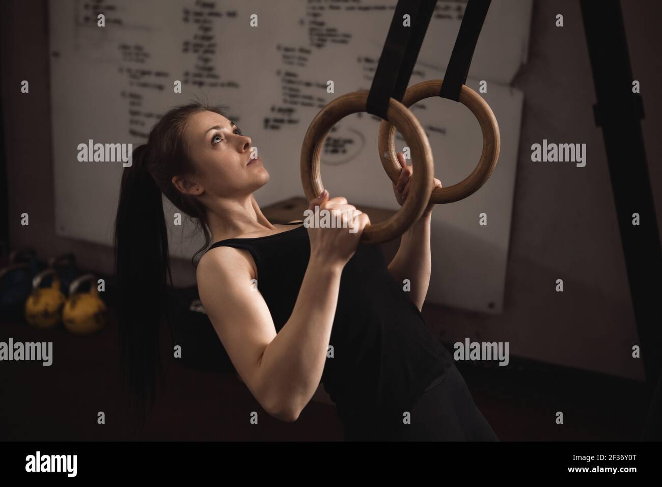 Femme sportive faisant des pull-ups sur les anneaux de gymnastique Banque D'Images