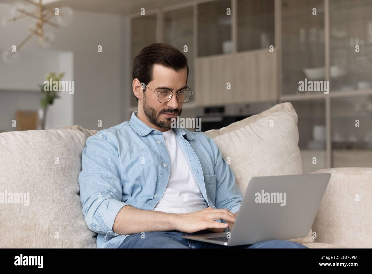Un jeune homme du Caucase travaille sur un ordinateur portable à la maison Banque D'Images