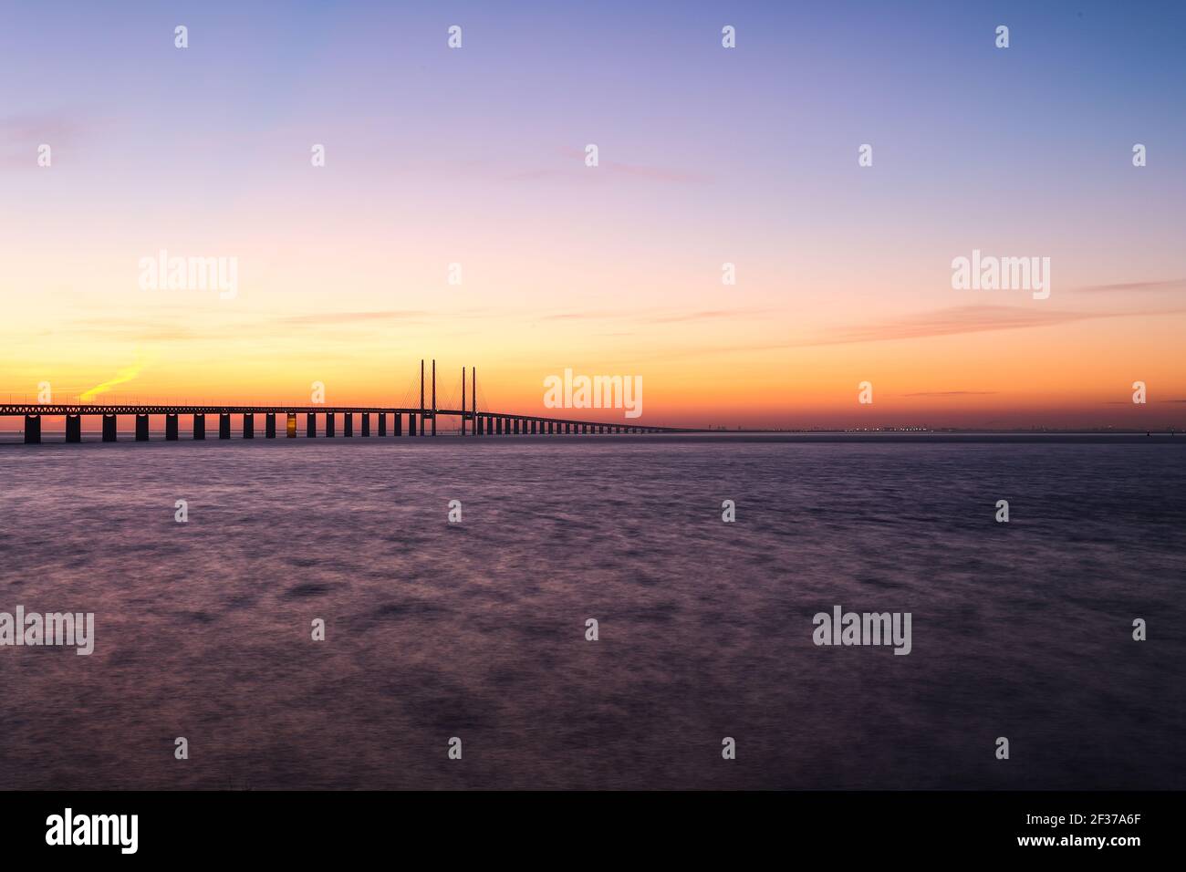 Coucher de soleil sur le pont d'Oresund au point de vue près de Limhamn, Suède, en février 2021. Grand angle, ciel clair, pont s'étendant de la gauche au ho Banque D'Images