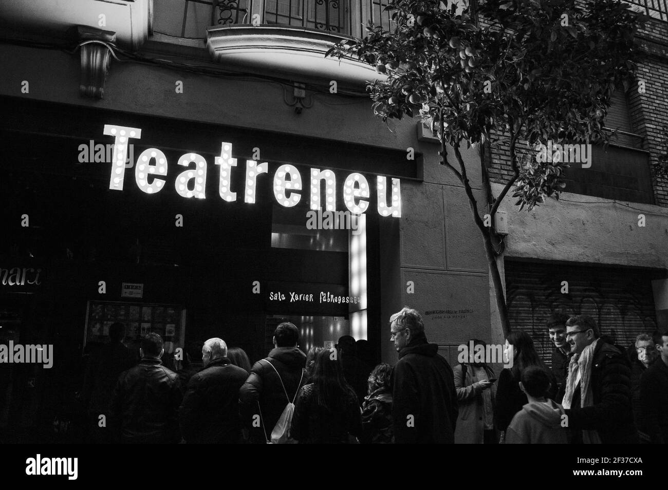 BARCELONE, CATALOGNE, ESPAGNE - 11 MARS 2018 : personnes attendant d'entrer au théâtre Teateneu dans le quartier Garcia le soir. Photo noir et blanc Banque D'Images