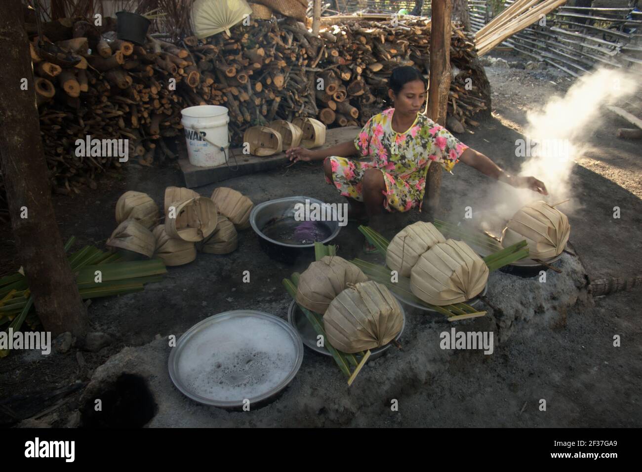 Une femme qui fait bouillir la sève de palmier pour faire du sucre de palmier dans le village d'Oehandi, île de Rote, Indonésie. Banque D'Images