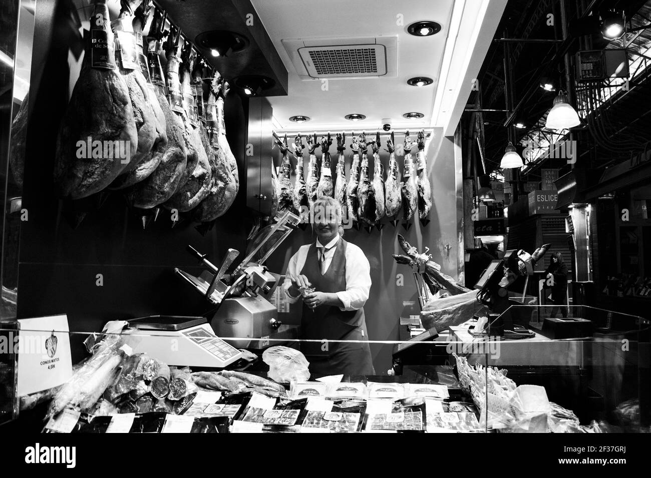 BARCELONE, ESPAGNE - 10 MARS 2018 : stand de jambon et de salami au célèbre marché alimentaire de Barcelone, la Boqueria. Photo historique noir blanc Banque D'Images