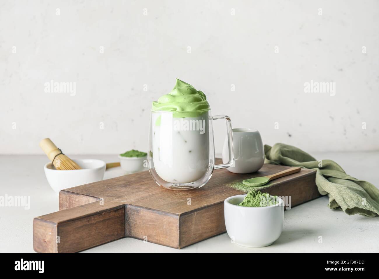 Composition avec délicieux Dalgona matcha latte sur fond clair Banque D'Images