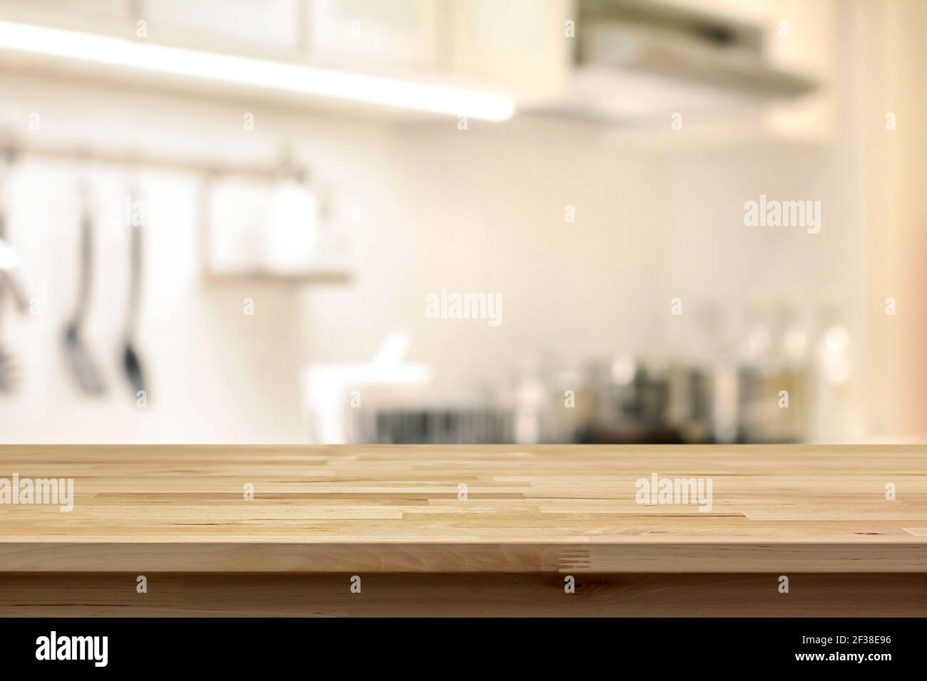 Table en bois (comme îlot de cuisine) sur fond de cuisine flou - peut être utilisé pour l'affichage ou montage de vos produits Banque D'Images