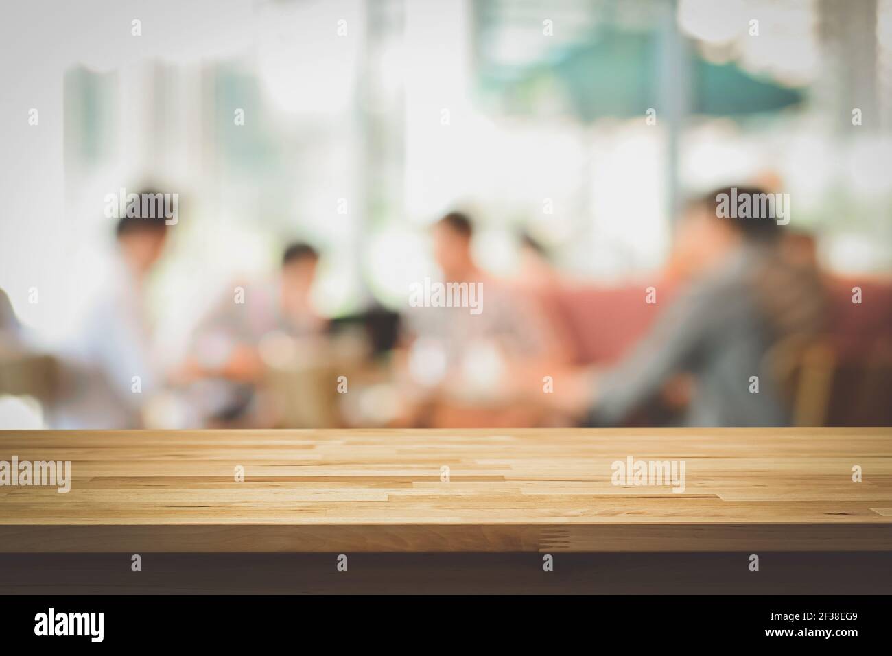 Plan de table en bois sur fond flou des gens dans le café, lomo et effets de ton vintage - peut être utilisé pour l'affichage ou le montage de vos produits Banque D'Images