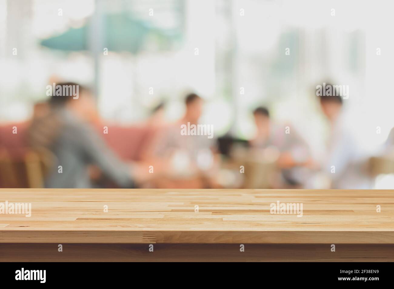 Plan de table en bois sur fond flou des gens dans le café, doux ton - peut être utilisé pour l'affichage ou le montage de vos produits Banque D'Images