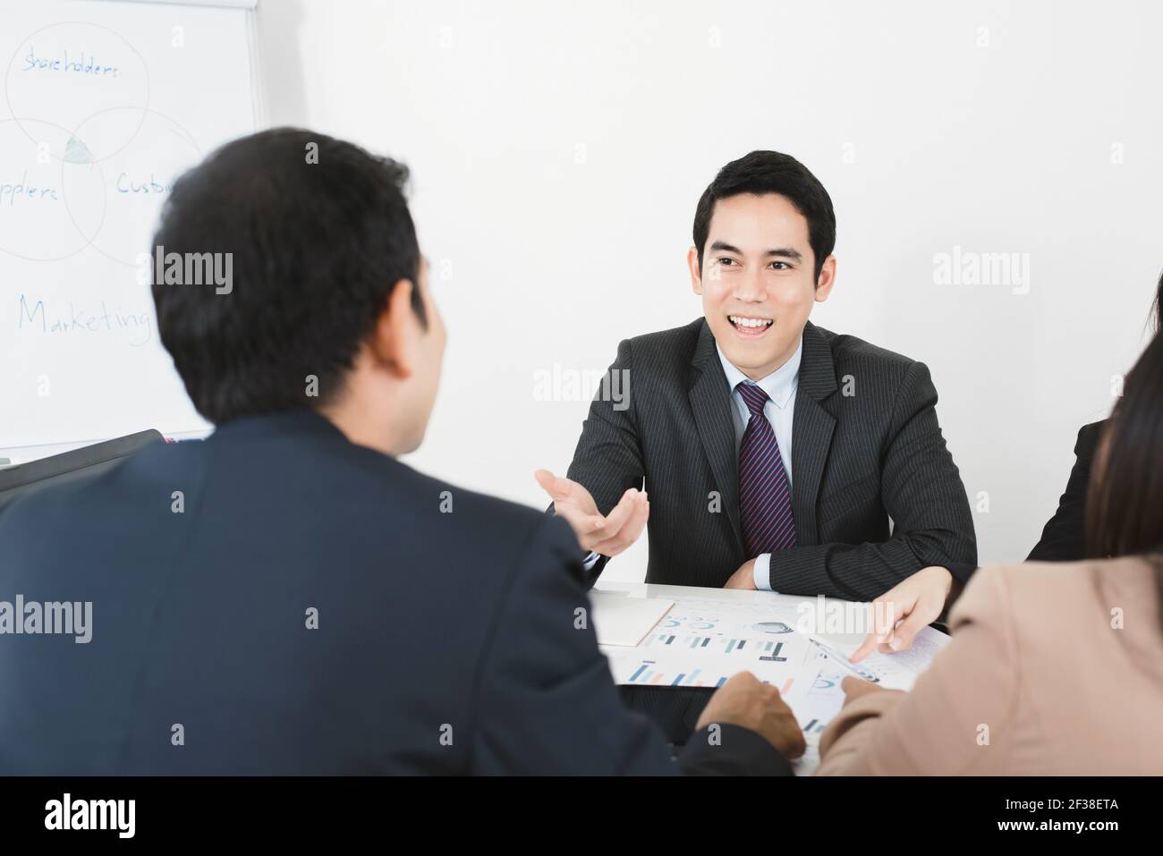 Beau homme d'affaires asiatique partageant son opinion lors de la réunion Banque D'Images