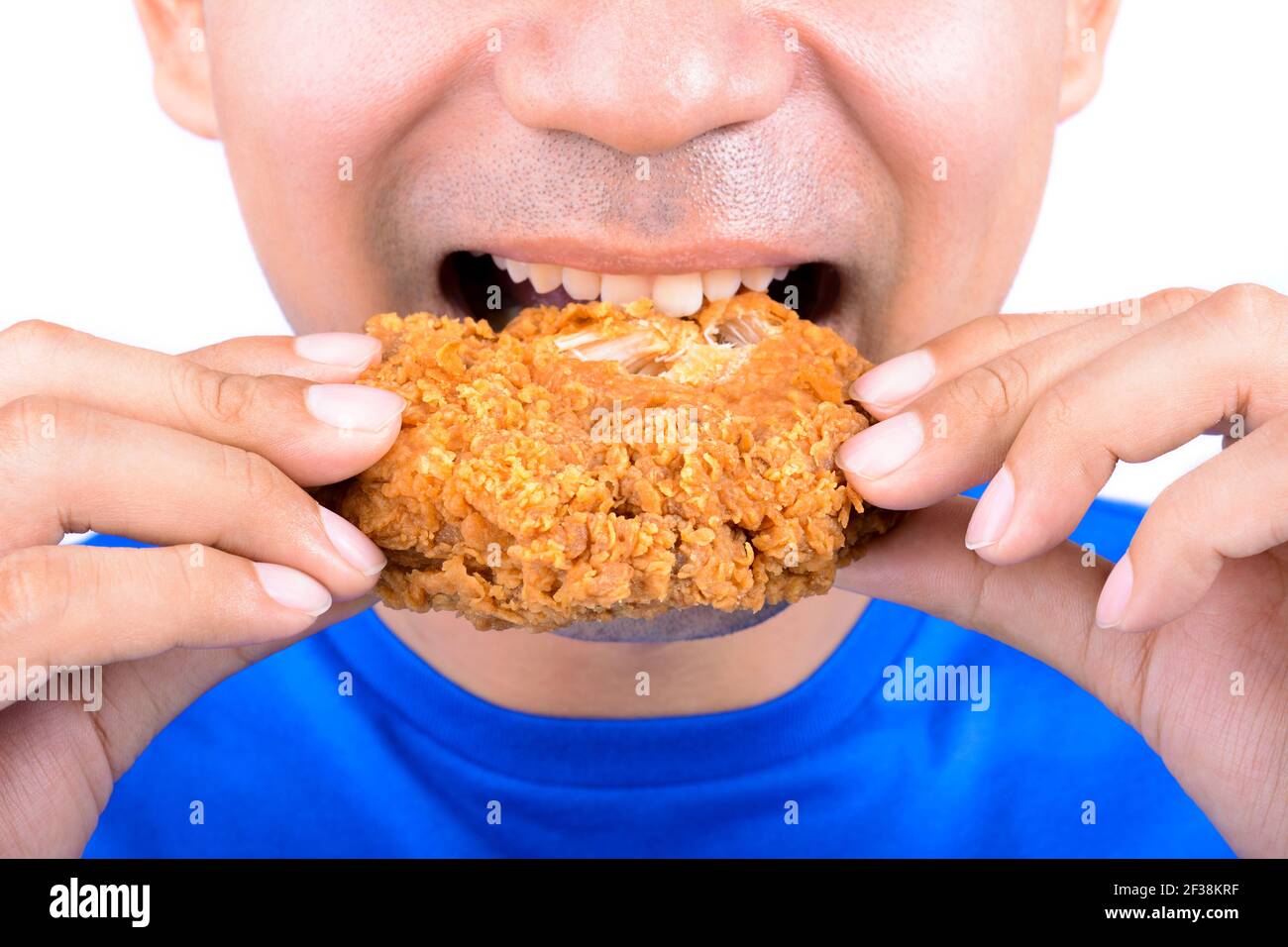 Jeune homme mangeant du poulet frit Banque D'Images