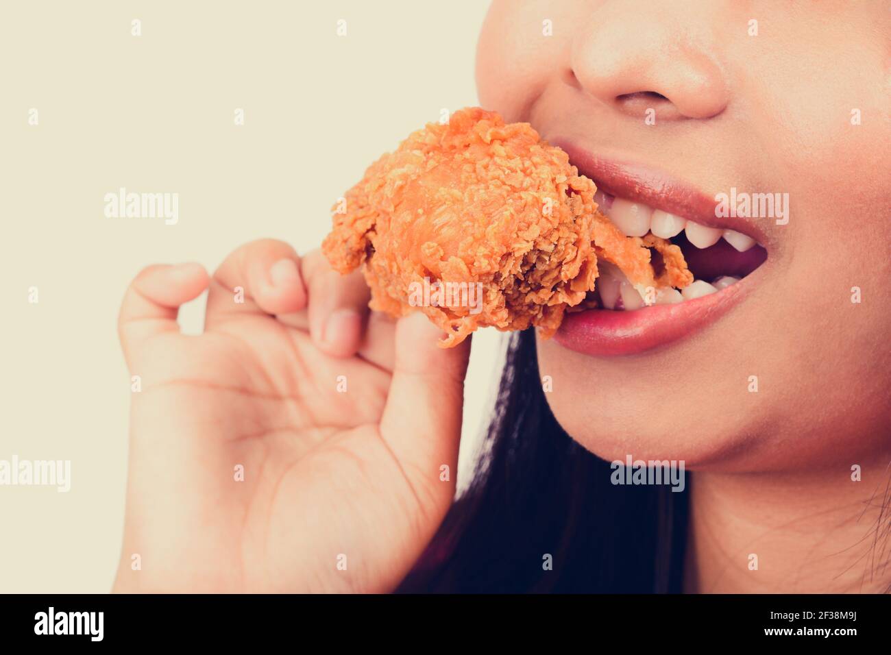 Jeune femme piquant du poulet frit, ton vintage Banque D'Images