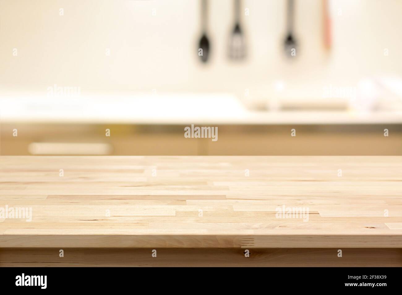 Table en bois (comme îlot de cuisine) sur fond de cuisine flou - peut être utilisé pour l'affichage ou montage de vos produits Banque D'Images