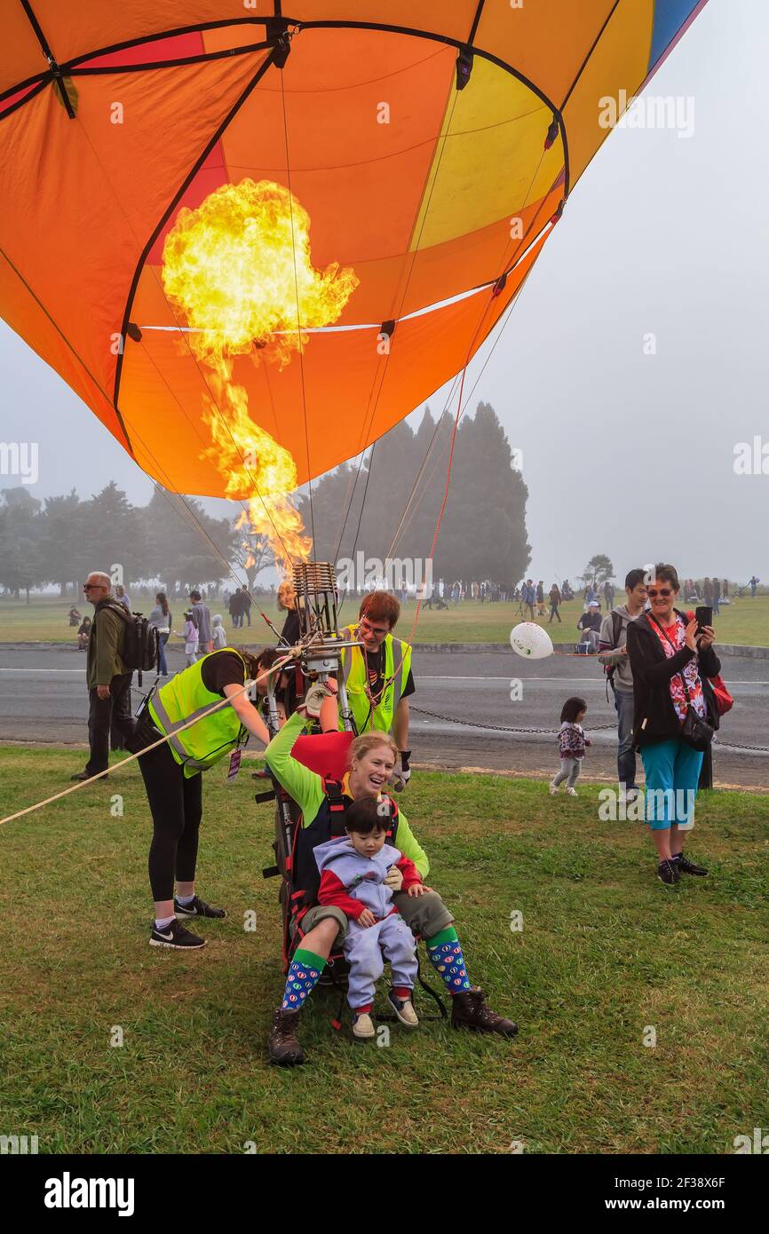 Une pilote femelle faisant la démonstration d'un « char » (montgolfière avec un siège unique) à un jeune enfant aux Balloons au-dessus du festival de Waikato, Hamilton, Nouvelle-Zélande Banque D'Images