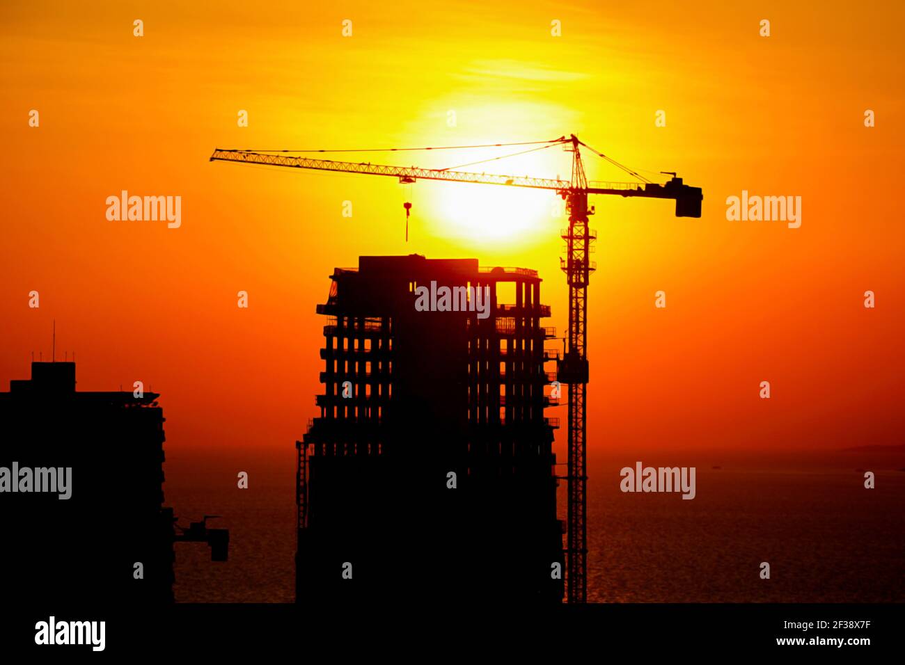 Silhouette de la tour de grue et des bâtiments en construction au crépuscule arrière-plan du coucher du soleil Banque D'Images
