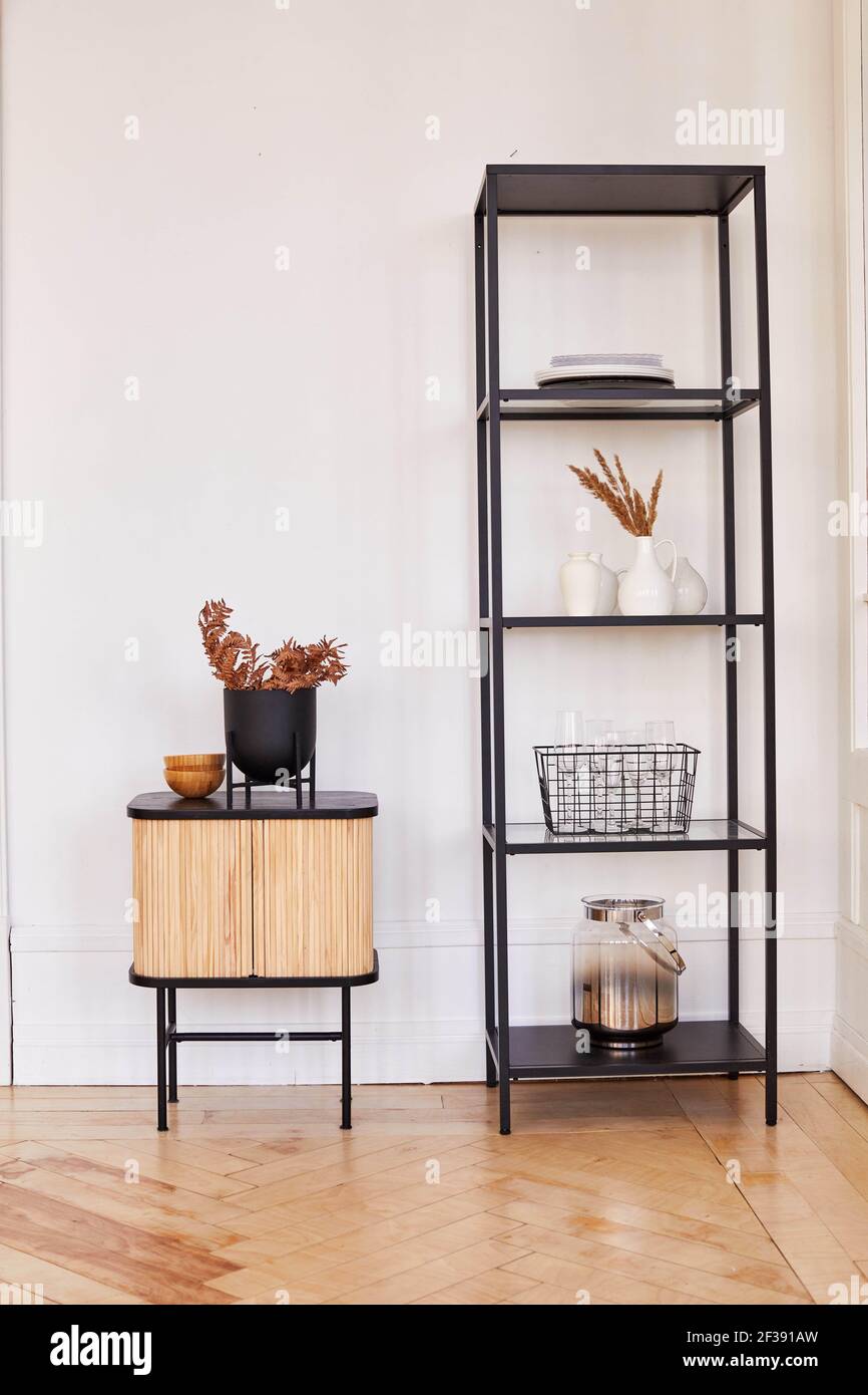 Étagères modernes en métal et armoire en bois avec décorations assorties placées dans la chambre dans un style minimaliste Banque D'Images