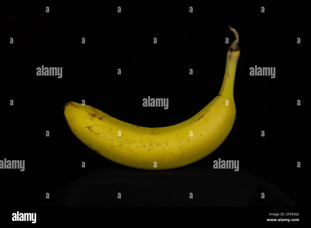 une banane jaune mûre isolée sur un fond noir Banque D'Images