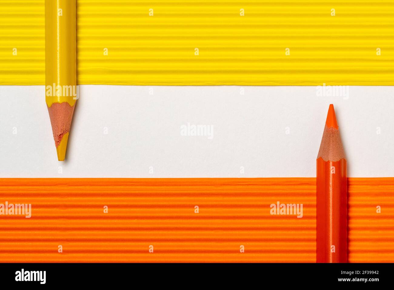 Crayons jaune et orange sur feuilles de papier de couleur avec copie espace pour votre texte Banque D'Images