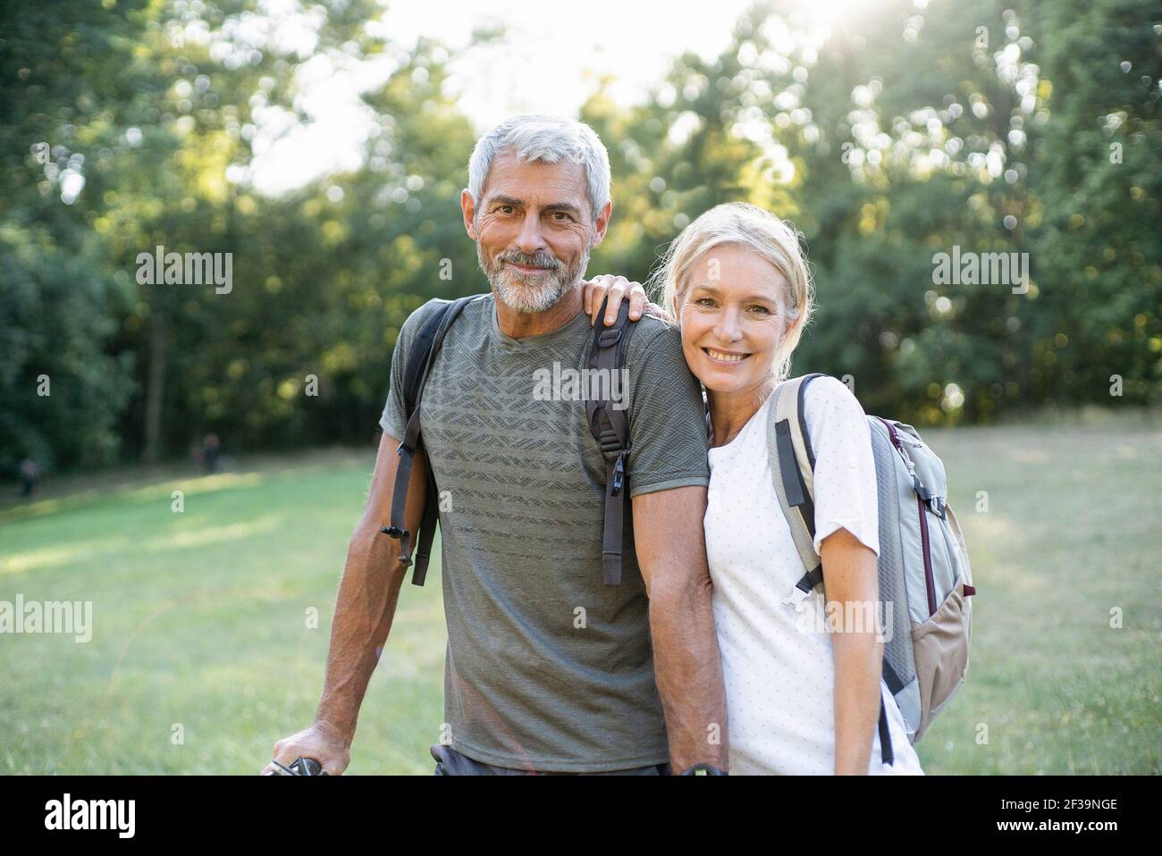 Portrait d'un couple mûr souriant debout en forêt Banque D'Images