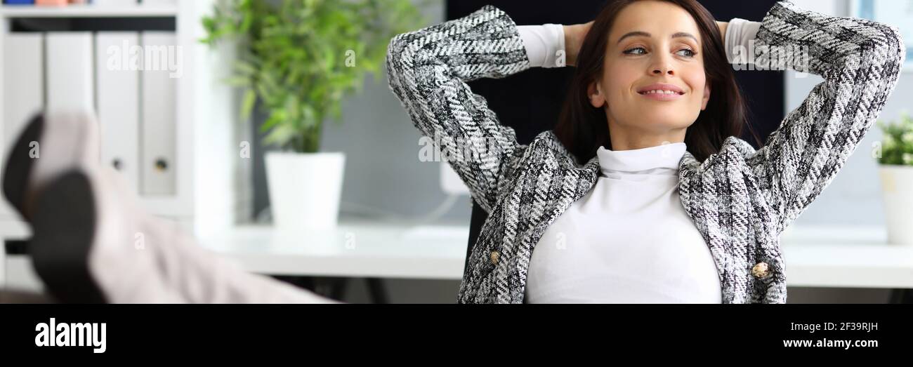 Belle femme au bureau avec ses pieds sur la table. Banque D'Images