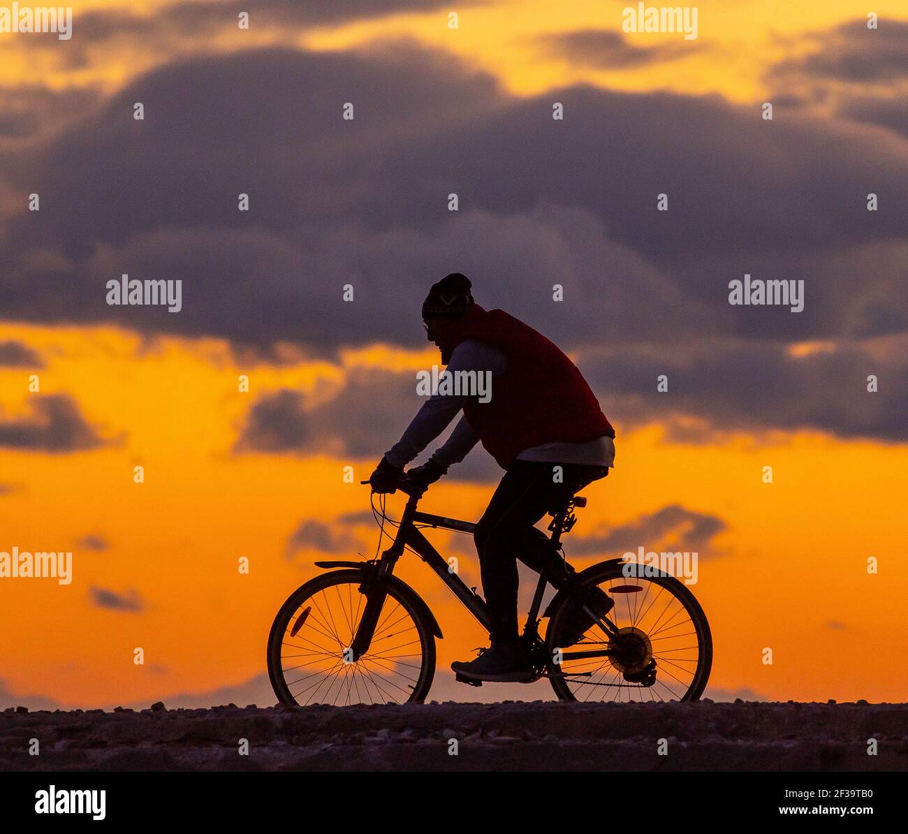 Un motard en face d'un coucher de soleil grec Banque D'Images